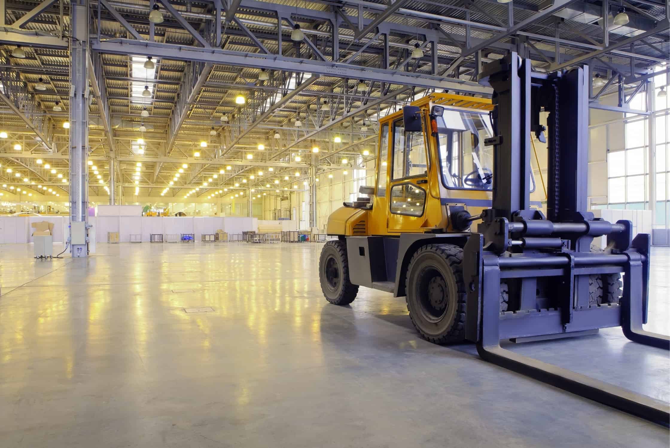 an unmanned forklift sitting in an empty warehouse