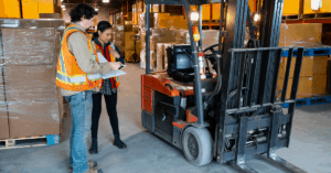 2 people inspecting a forklift