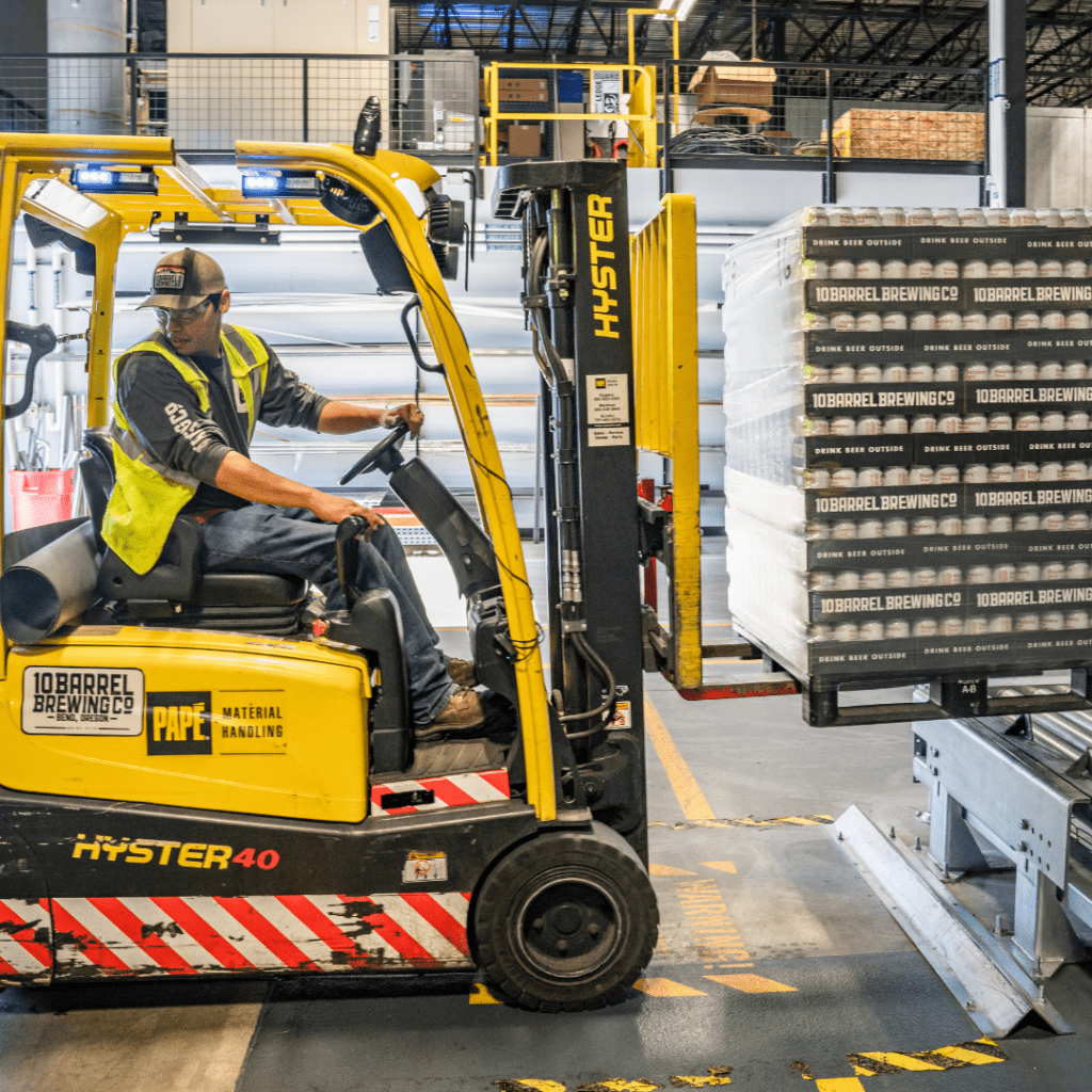 Forklift delivering pallet onto conveyor belt