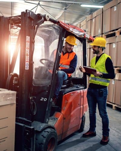 Forklift driver and warehouse manager discuss forklift safety plan