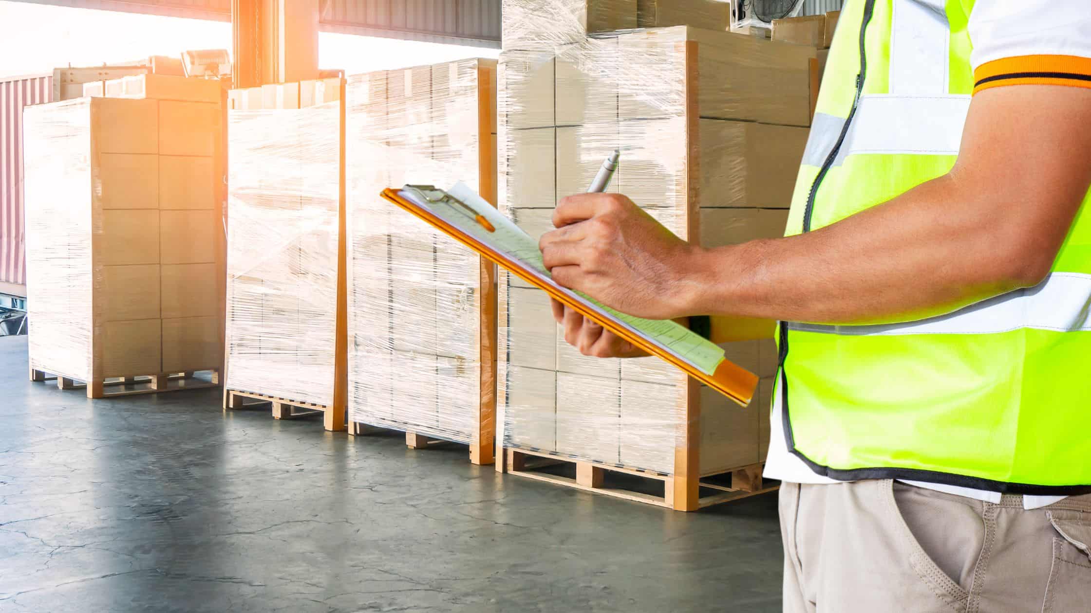 Man in warehouse with clipboard for safety